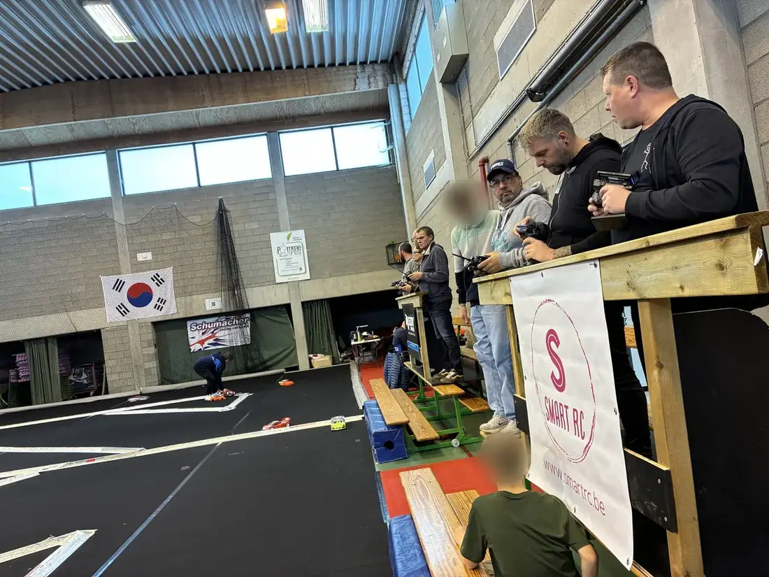 Les pilotes sur le podium, bâche Smart RC en bord de piste